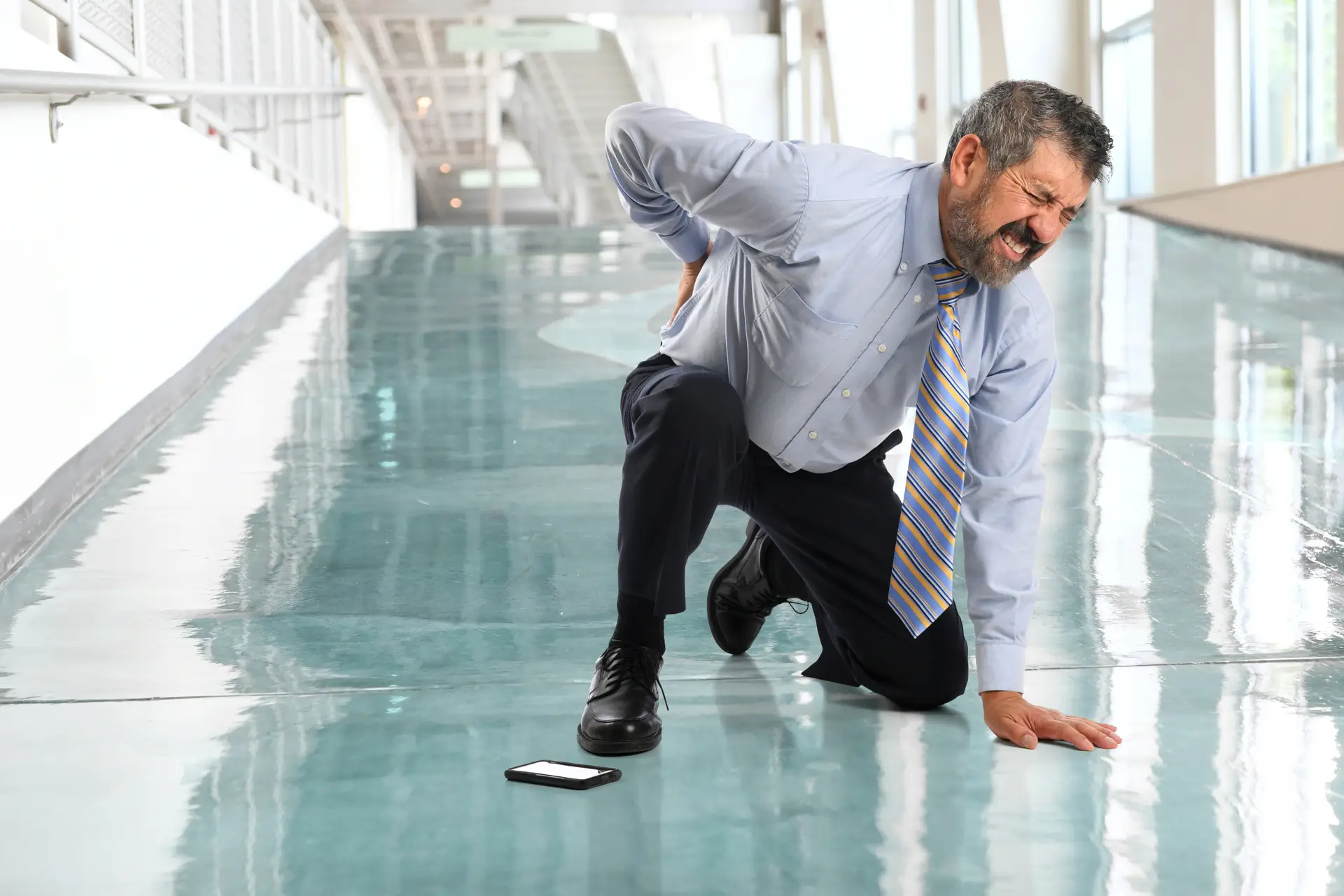 man holding his back in pain from a slip and fall